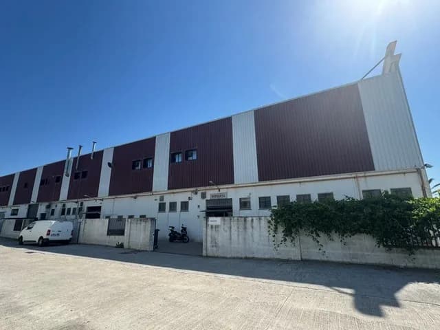 The Casadevall Espiarva metalwork factory, a long production hall under a clear sky.